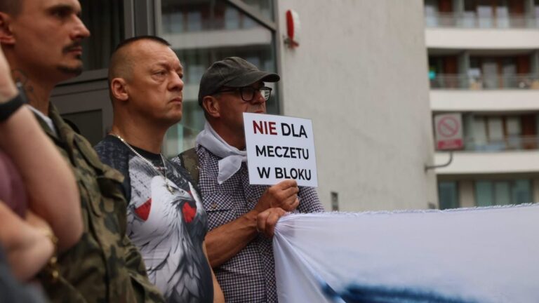A resident holding a sign that reads “No mosque in the building”