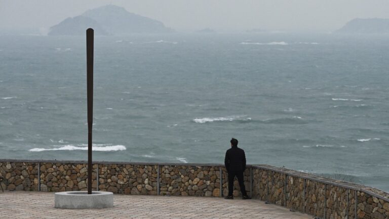 A man looks out over stormy seas in the Taiwan Strait, from Pingtan Island, the closest point in China to Taiwan’s main island, in China's southeast Fujian province on January 15, 2024.