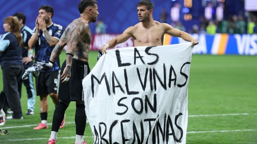 Argentina’s defender Nicolás Otamendi (L) and midfielder Giovani Lo Celso show a banner that reads in Spanish, “The Malvinas (Falkland Islands) belong to Argentina,” after winning the 2026 World Cup football tournament semi-final match between England and Argentina at the Atlanta Stadium in Atlanta on July 15, 2026.