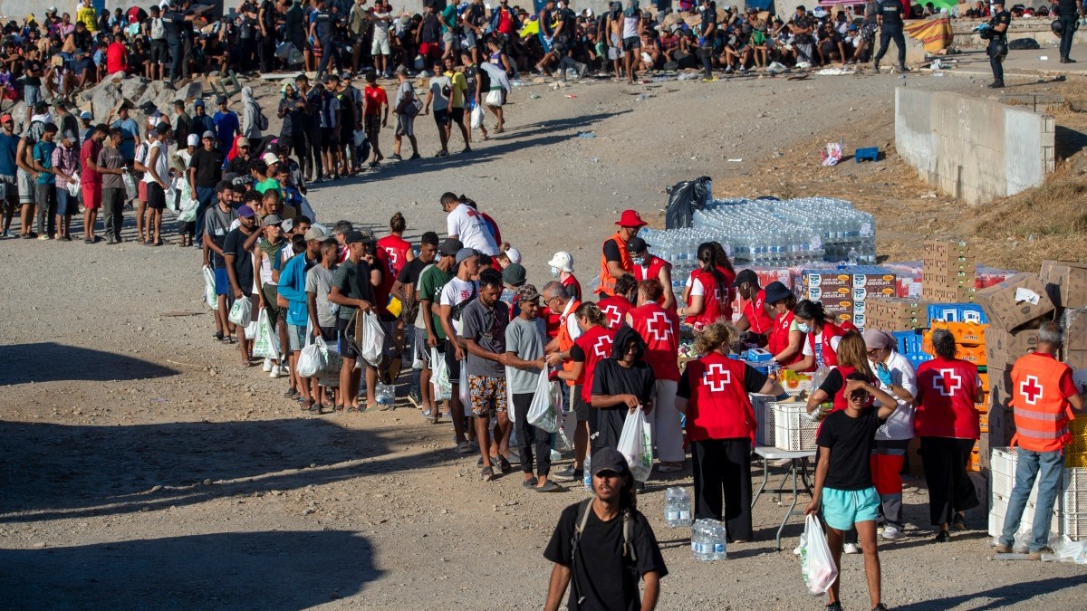 Red Cross volunteers distribute food to migrants living on the streets, at Trampolín beach in Ceuta, on August 22, 2026.