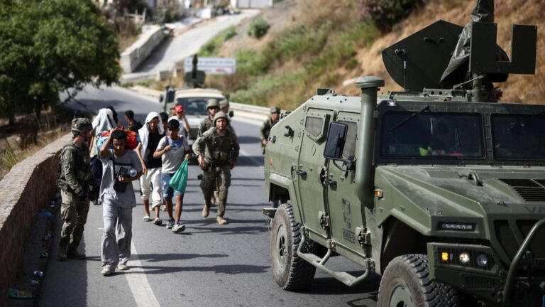Spanish soldiers escort migrants to the border in the Spanish North African enclave of Ceuta on August 1, 2026.