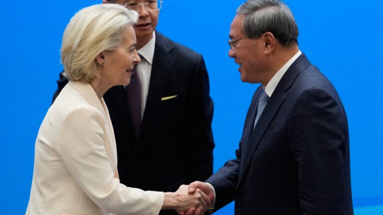 European Commission President Ursula von der Leyen (L) shakes hands with Chinese Premier Li Qiang during the EU-China Business leaders symposium at the Great Hall of the People in Beijing on July 24, 2025.