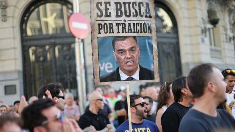 A protester holds a banner mocking Spain’s Prime Minister Pedro Sánchez reading “Wanted for treason” during a demonstration one month after a mass influx of migrants in Ceuta, in front of the Spanish Parliament in Madrid, on September 2, 2026.